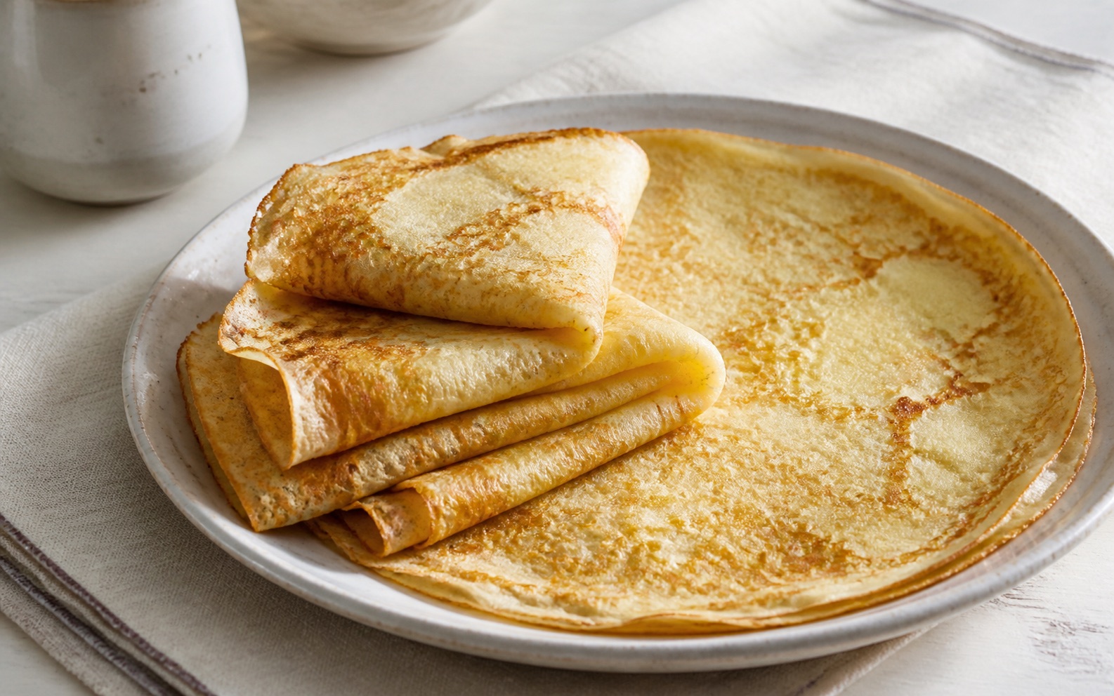 Crêpes françaises fines et dorées pliées sur une assiette